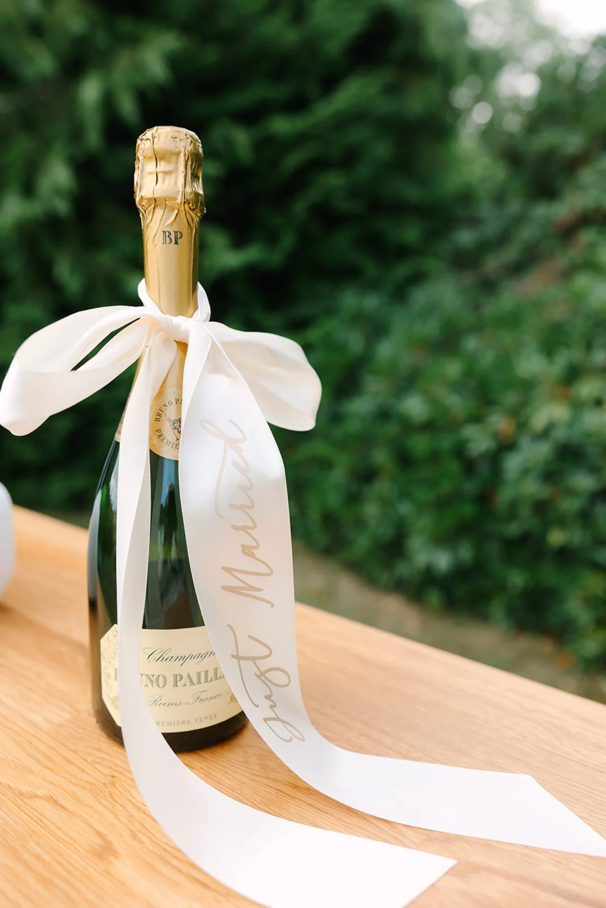 Just Married satin ribbon personalized with heat transfer vinyl tied onto a champagne bottle