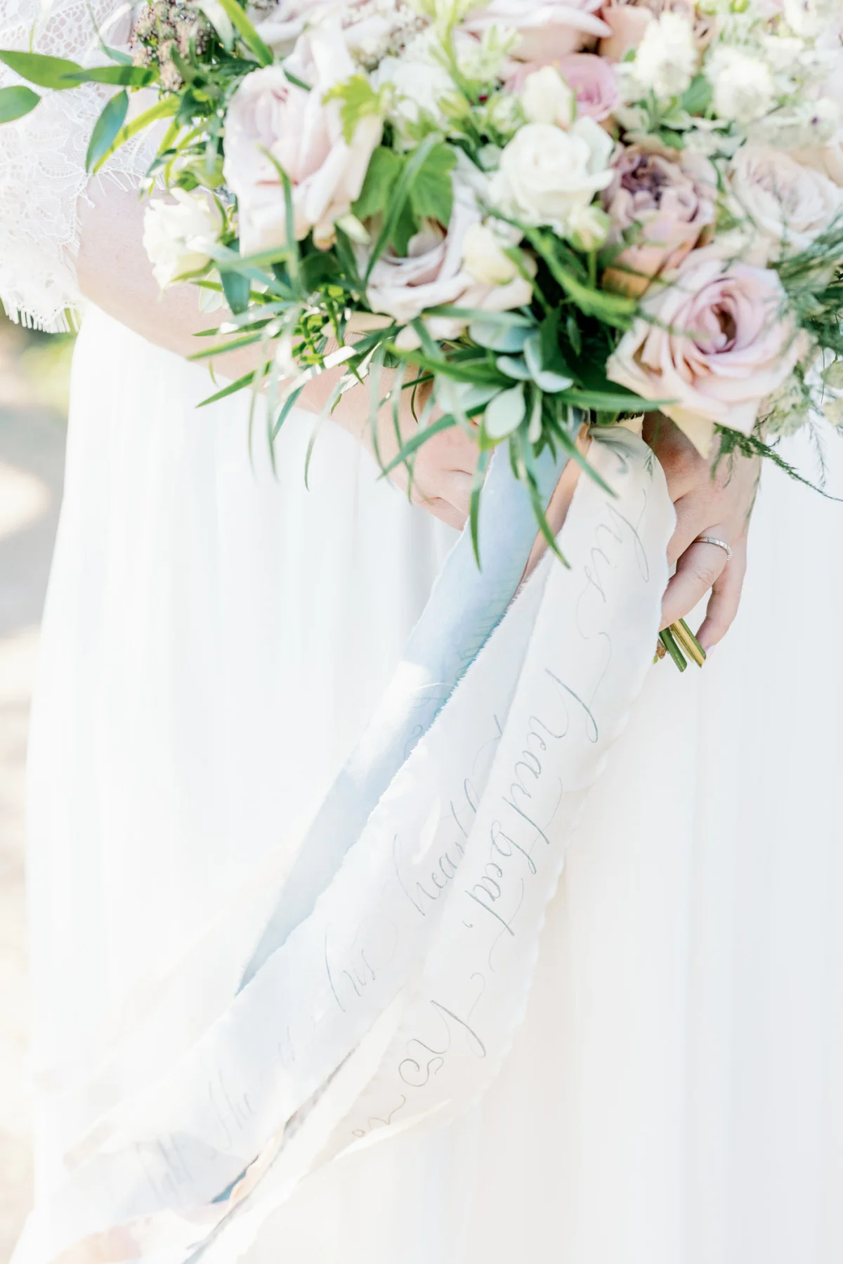 Delicate handwritten calligraphy in silver ink on wedding bouquet ribbons