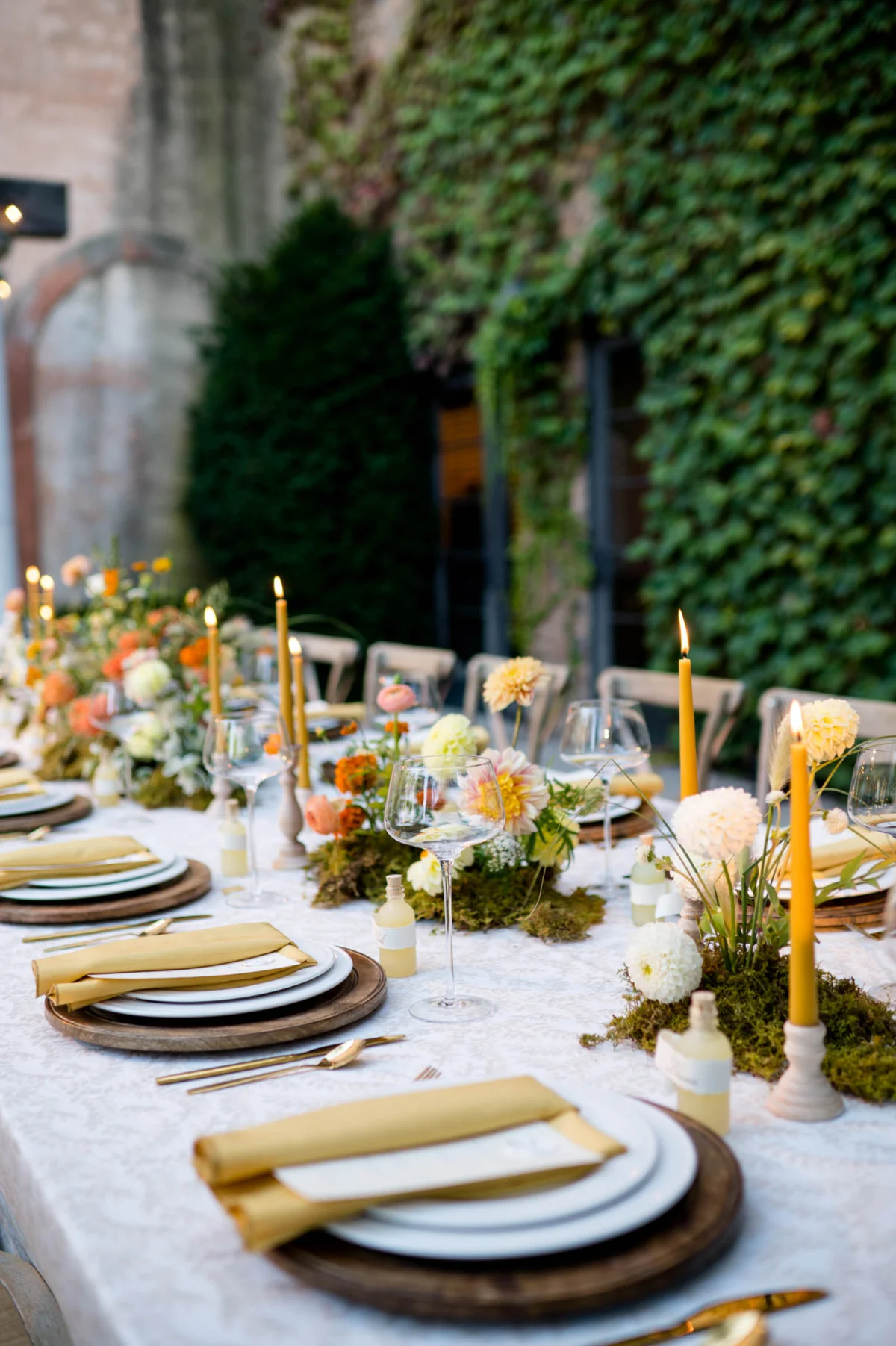 Fall wedding table decor ideas with mustard yellow candlesticks and minimal mossy flower centerpieces