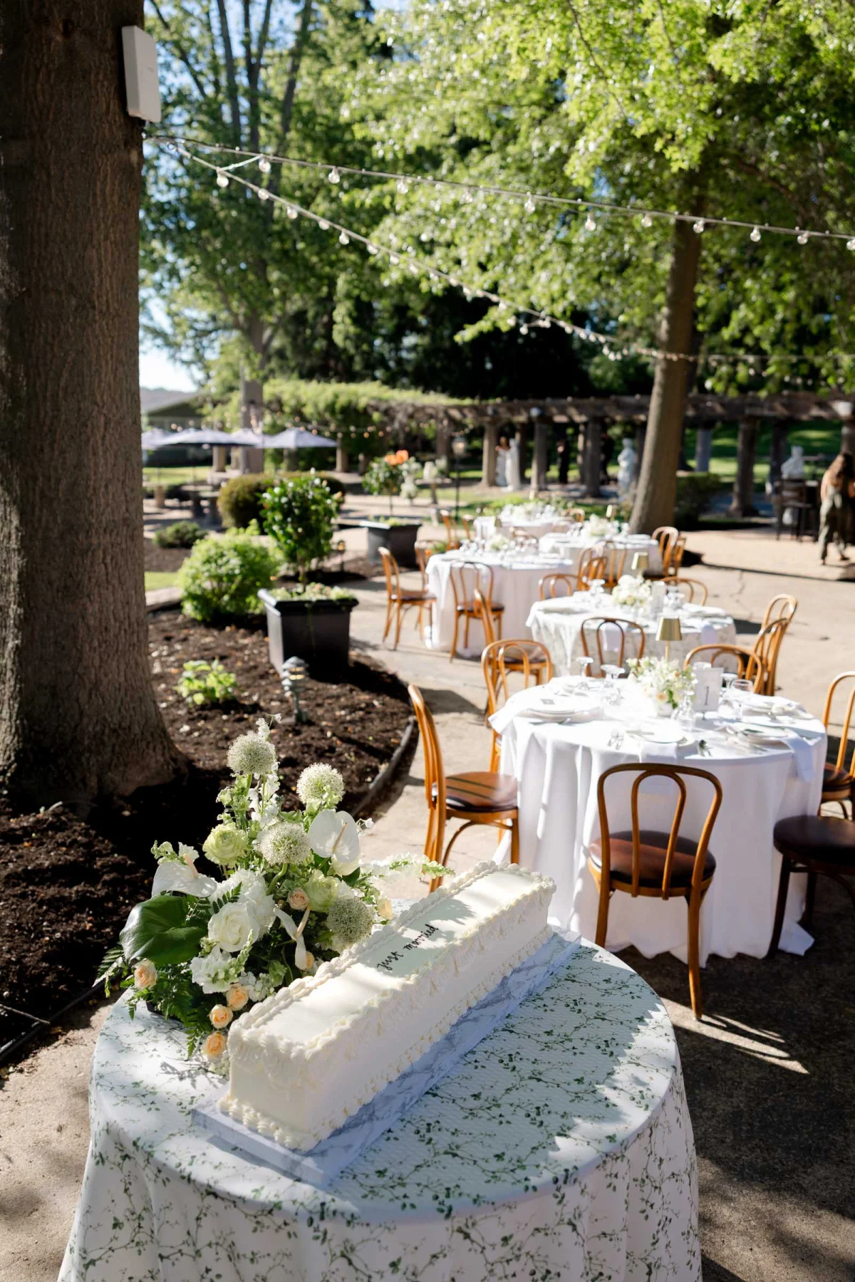 Classic modern long white wedding cake with Just Married written in black frosting for outdoor patio wedding