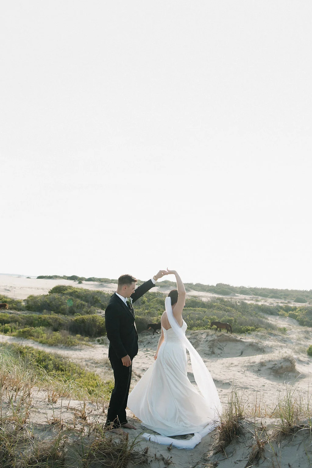 A newly married bride and groom in Corolla Outer Banks with wild horses