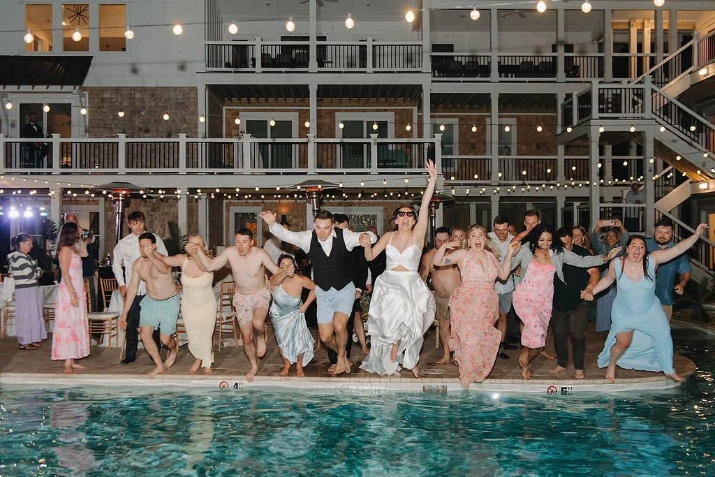 Bride and groom jumping into the beach house pool after their wedding reception in Outer Banks