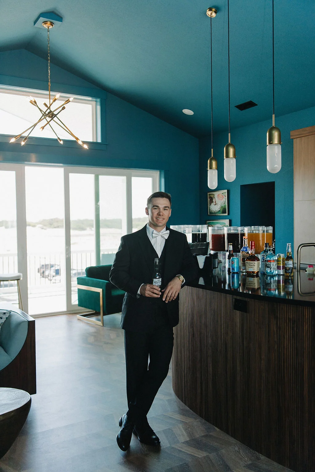 Groom drinking a Corona beer at his luxury beach house wedding in Outer Banks