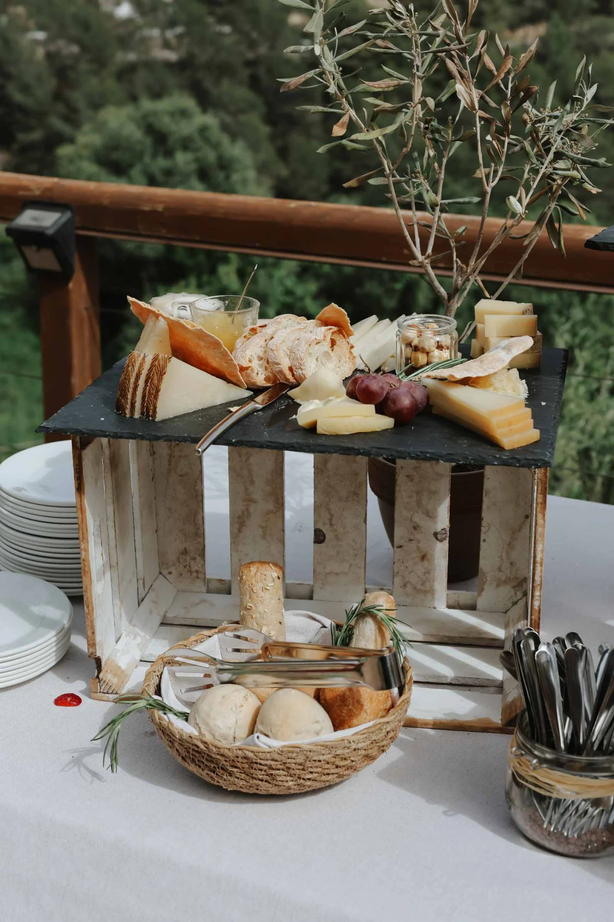 A rustic cheese charcuterie display with bread in baskets for Spanish wedding cocktail hour