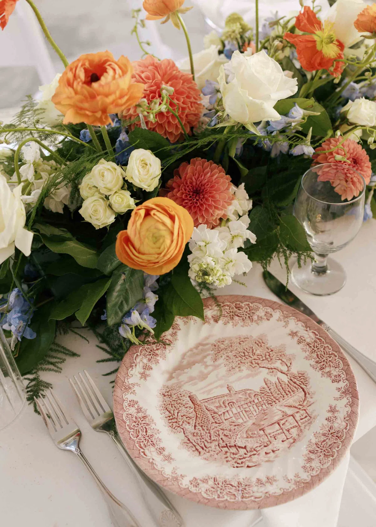 Mismatched thrifted vintage china plates on a colorful flower table setting