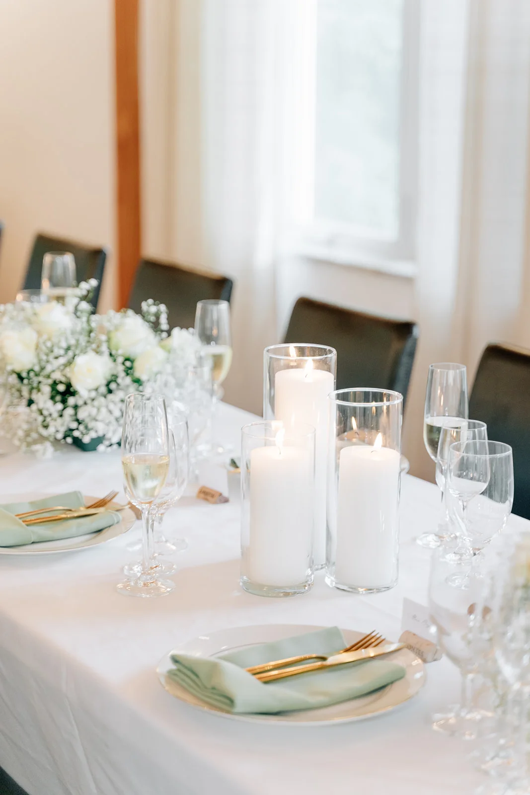 Mismatched clear glassware for candle holders on a wedding reception table
