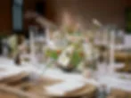 Elegant wedding reception table with wildflower centerpiece, tall taper candles, and wooden charger plates for a budget-friendly wedding table decoration
