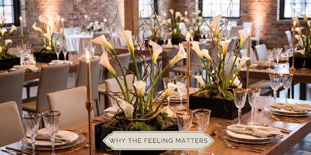 Elegant wedding reception table with white calla lily centerpieces, candles, gold accents, and a warm luxury dining atmosphere.