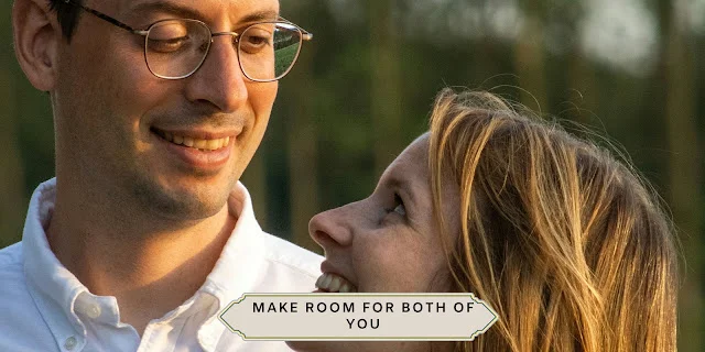 WEDDING THAT WORKS FOR BOTH OF YOU Smiling couple standing outdoors in soft evening light; he wears glasses and a white button-down shirt, and she wears a mustard-colored top.